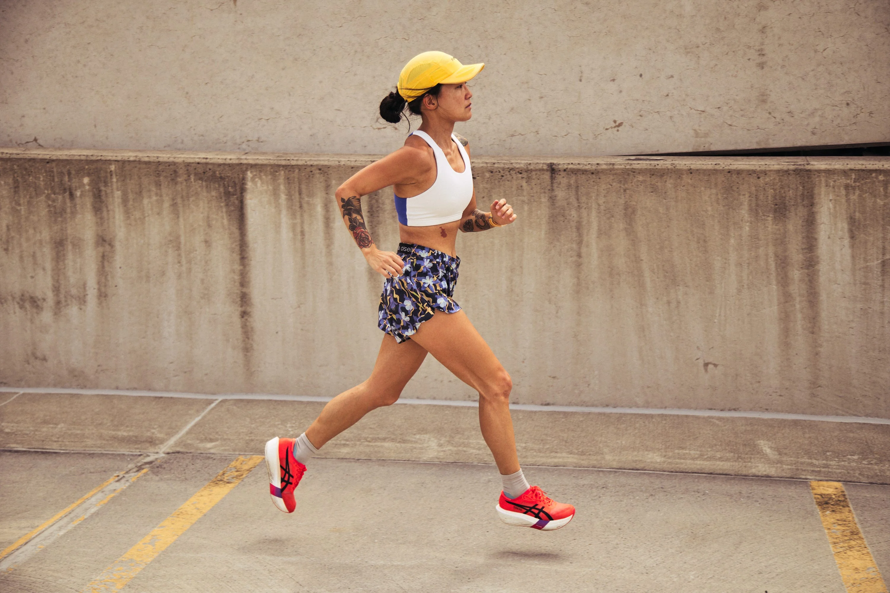 Woman in athletic wear running on concrete pavement.