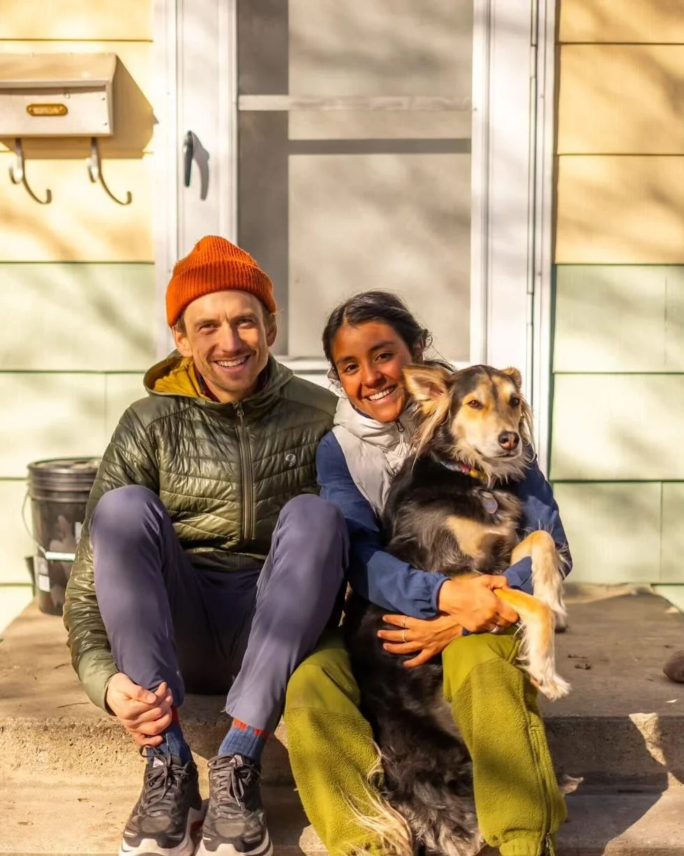 a casual scene featuring two seated individuals on a porch step one holding a dog