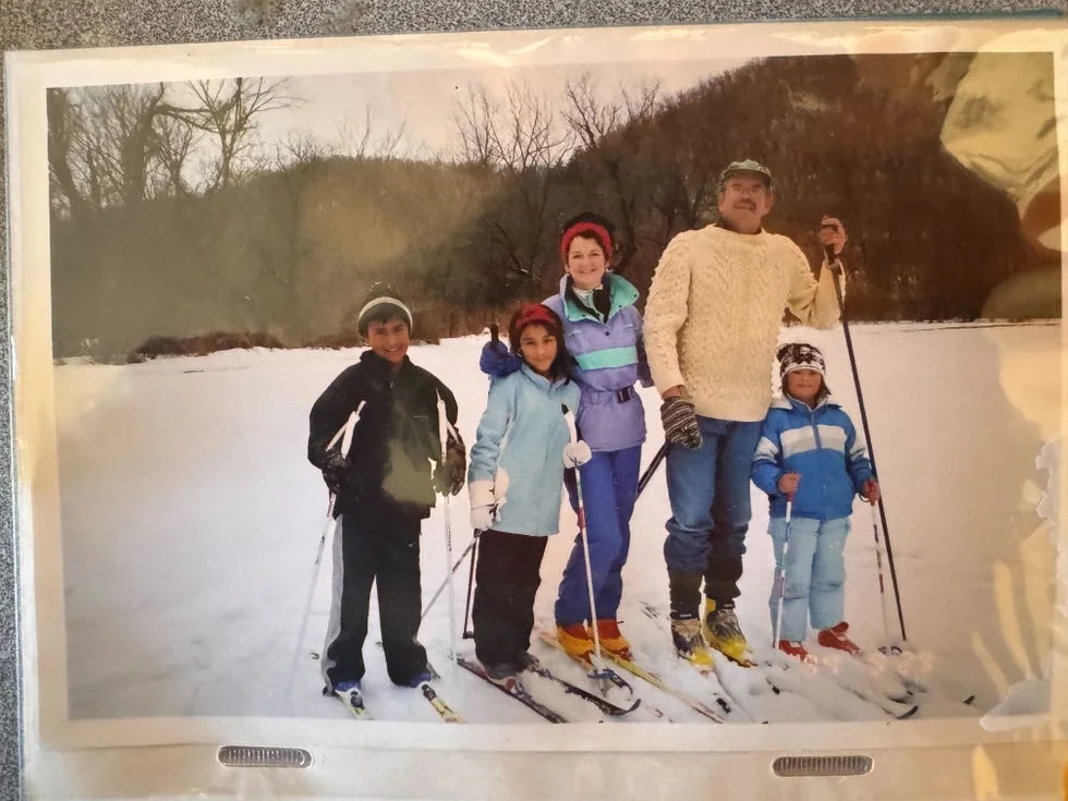 family posing for a photo with skis on