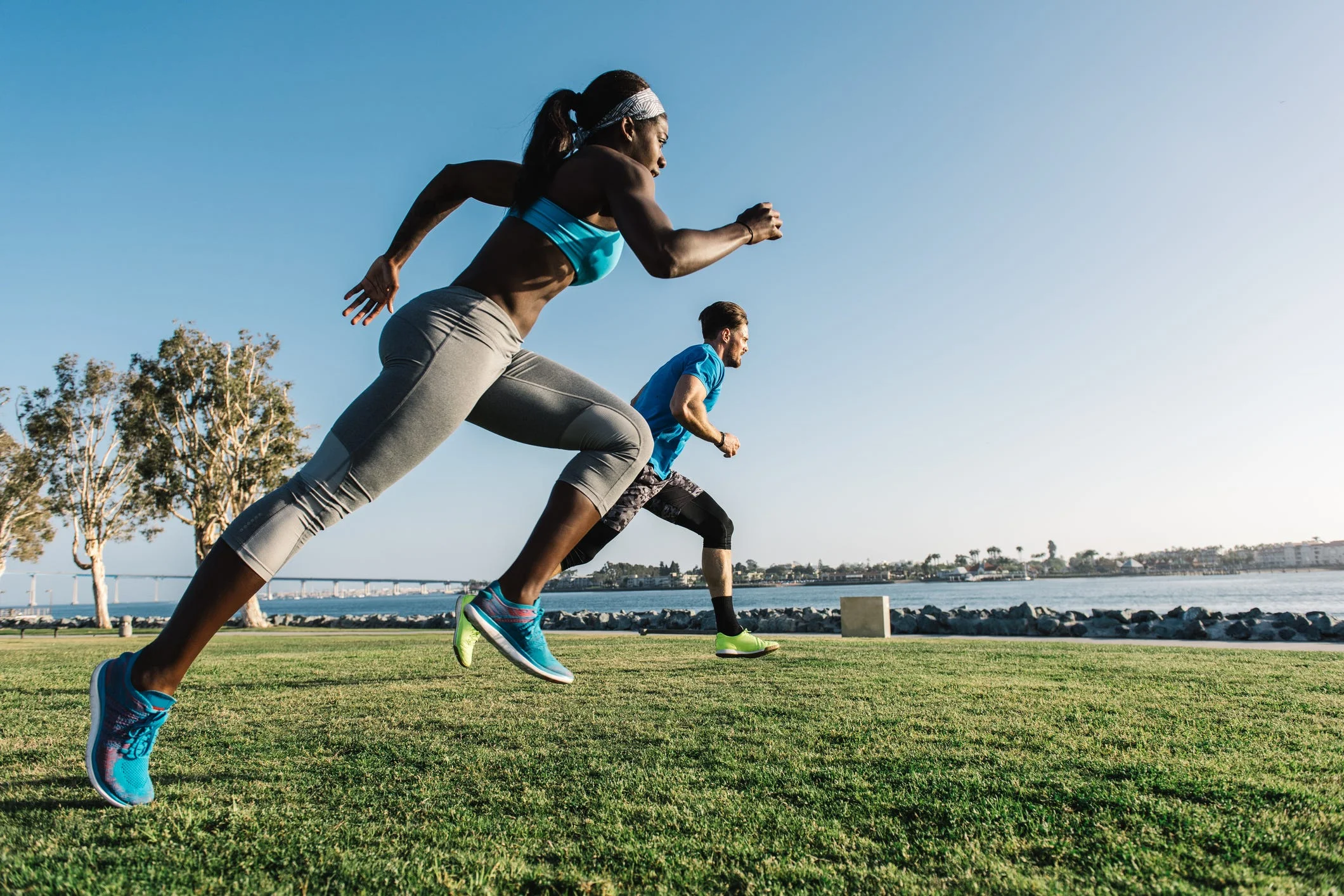 Man and young woman training, sprinting on coast, downtown San Diego, California, USA Man and young woman training, sprinting on coast, downtown San Diego, California, USA
