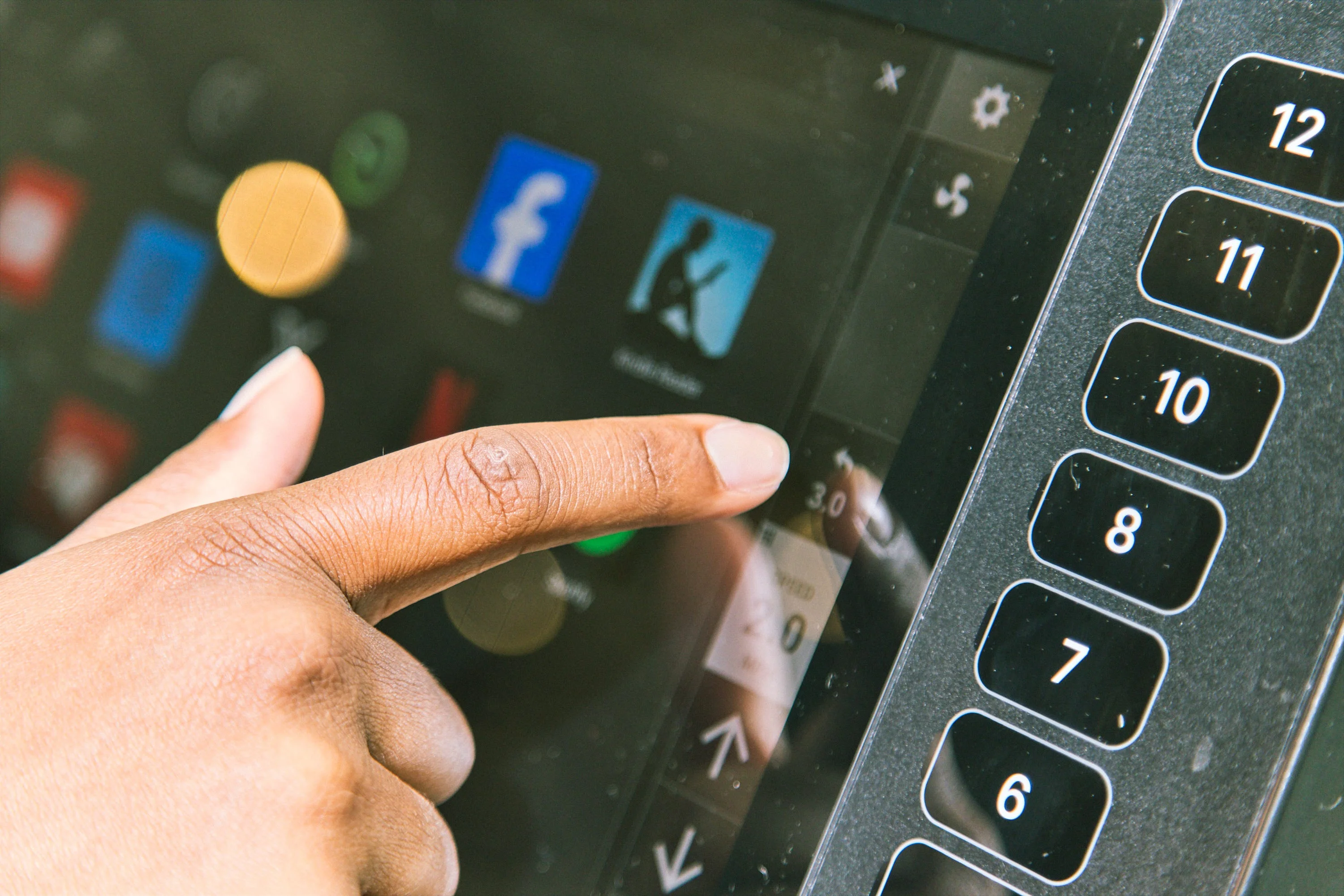 Finger pressing a touchscreen interface with various app icons displayed. Finger pressing a touchscreen interface with various app icons displayed.