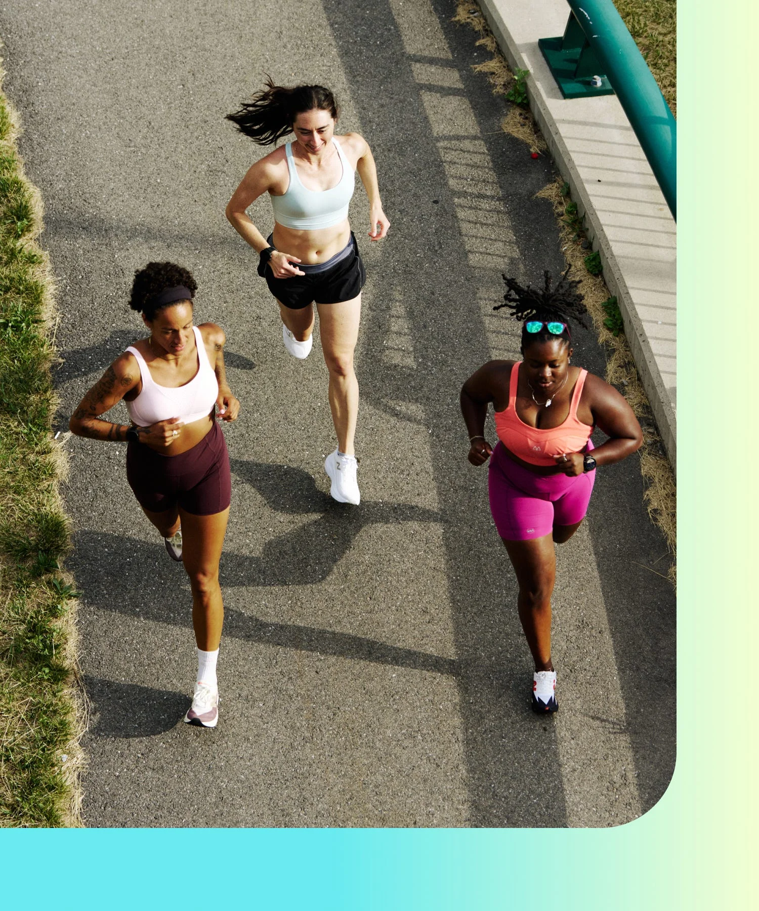 three runners in sports bras on paved path