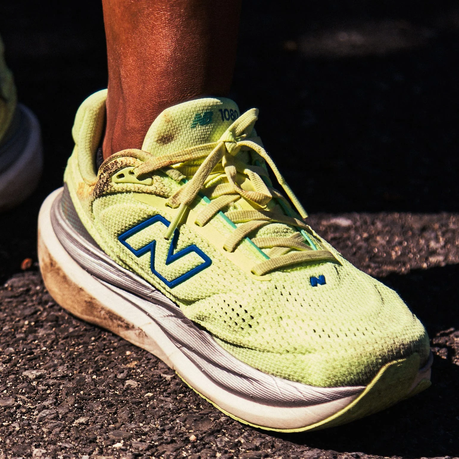 Bright yellow New Balance running shoes on a pavement surface. Bright yellow New Balance running shoes on a pavement surface.