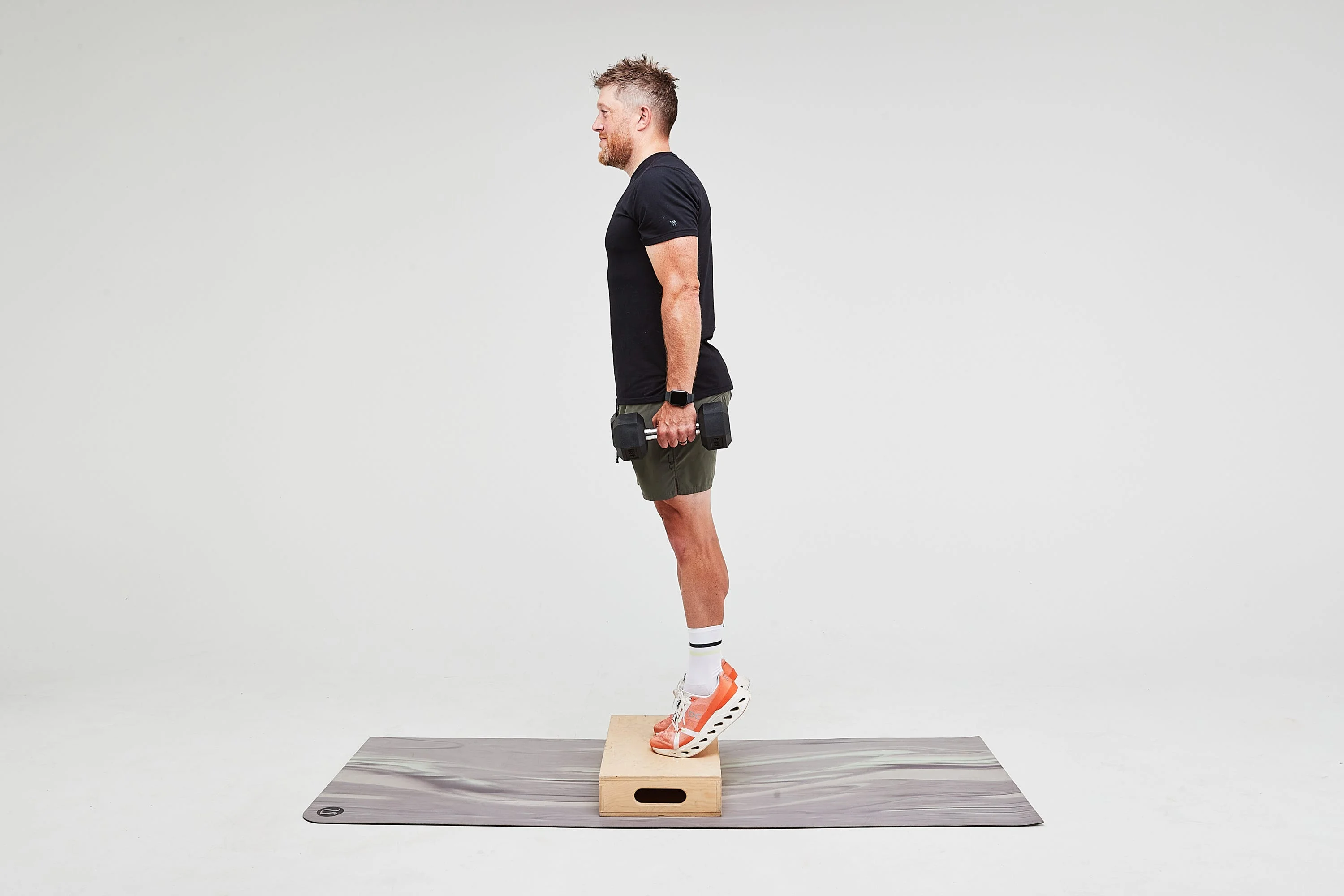 Person performing an exercise on a platform with dumbbells.