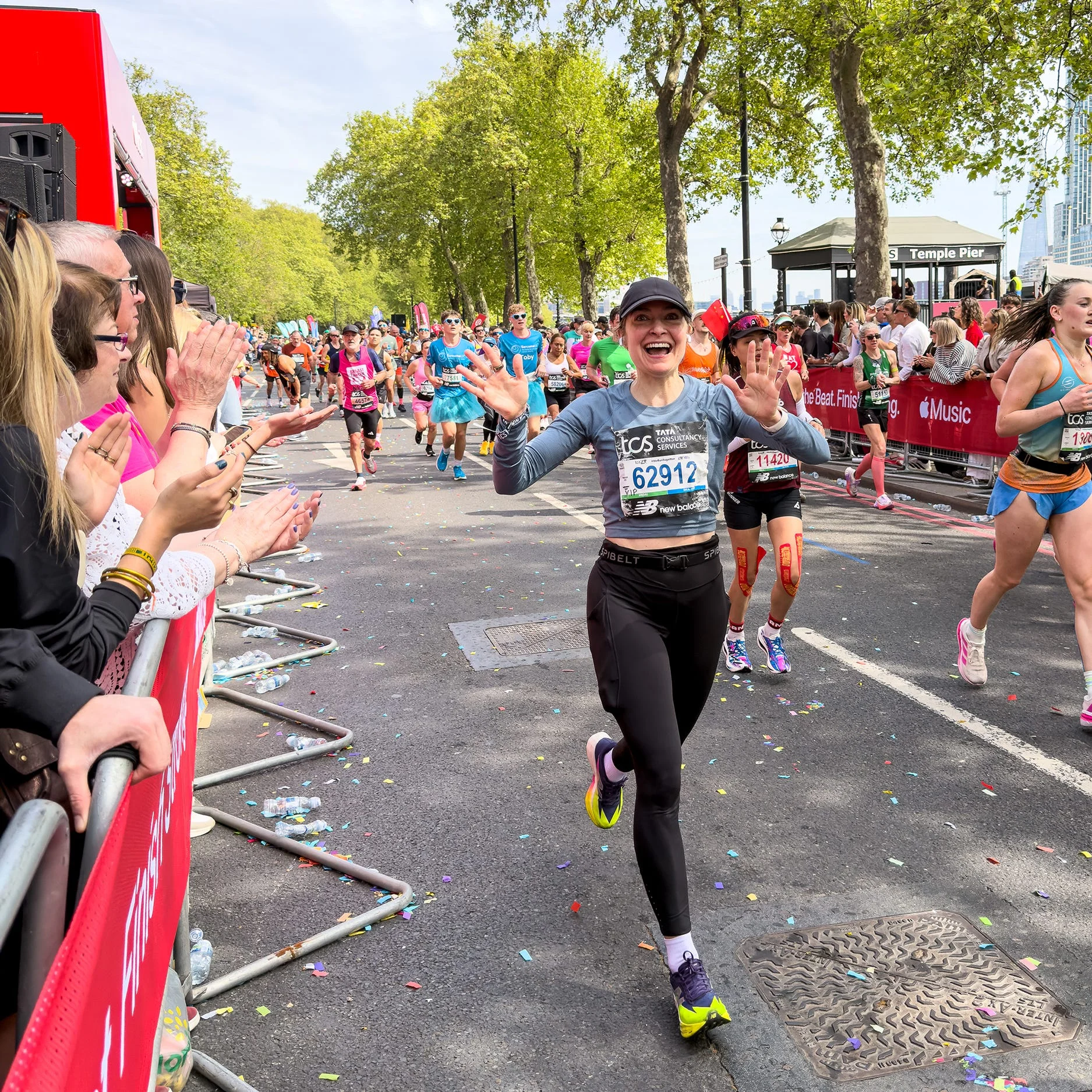 Runners participating in a marathon with spectators cheering alongside the course.