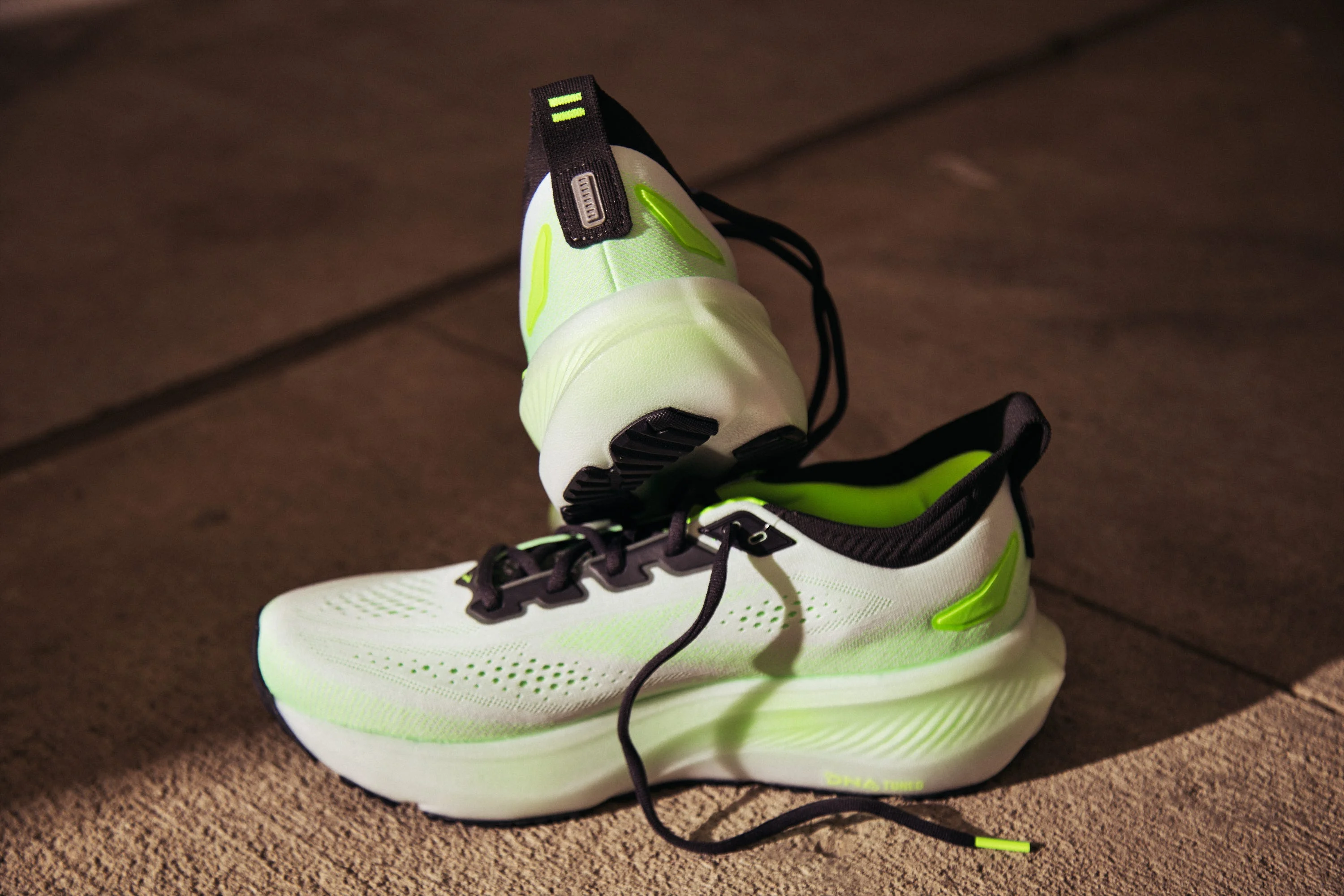 Pair of neon green and black running shoes on concrete surface