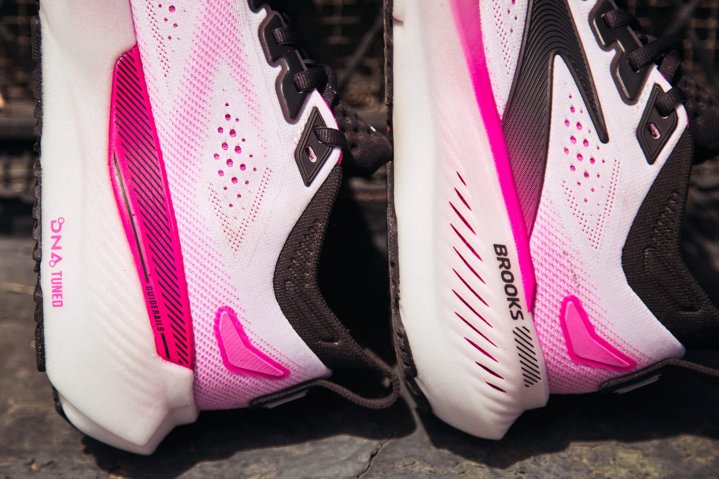 Close-up of black and white running shoes with pink accents.