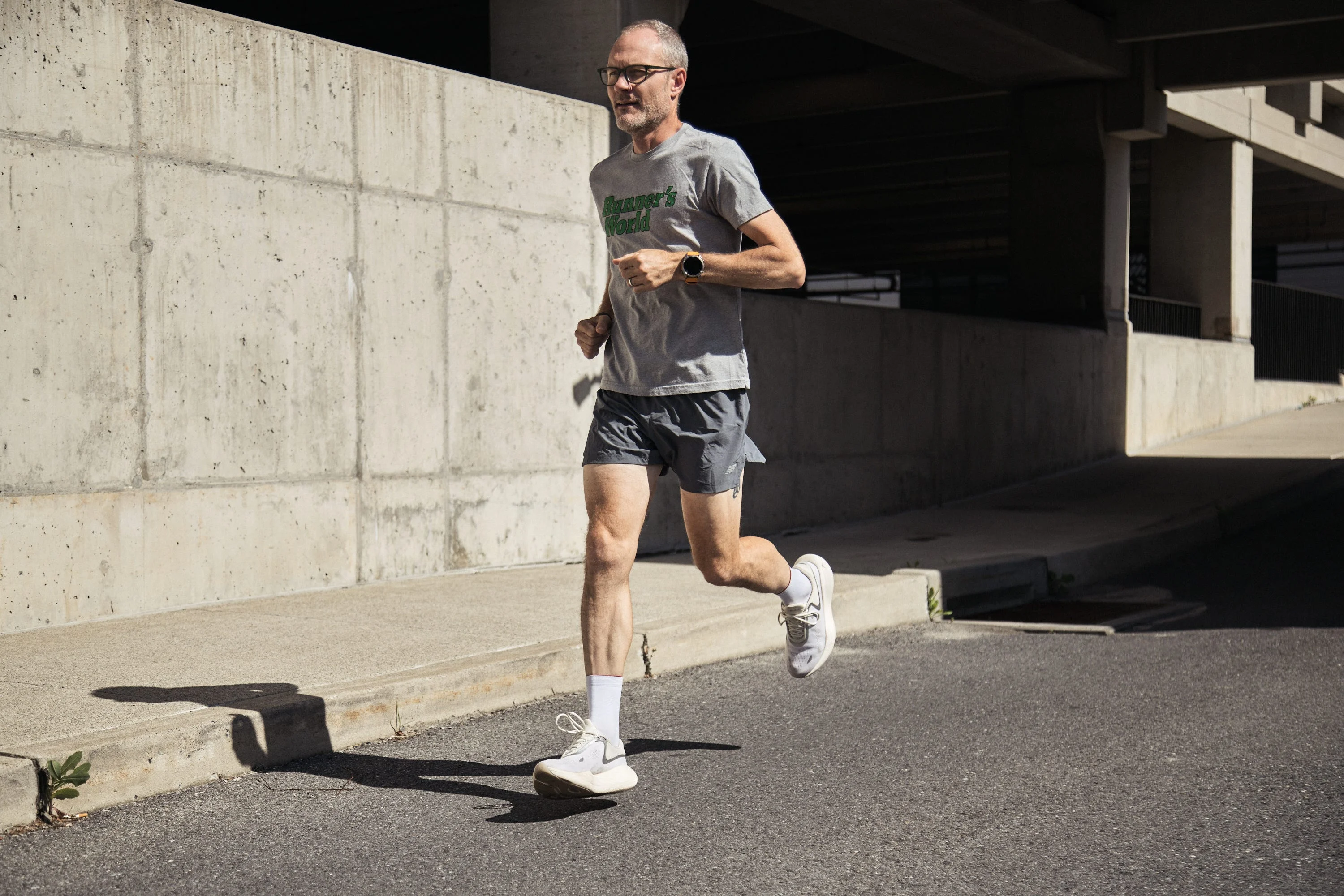 Person jogging on a city sidewalk in casual athletic attire.